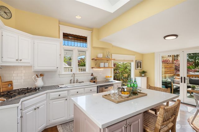 a kitchen with granite countertop a sink stove and cabinets