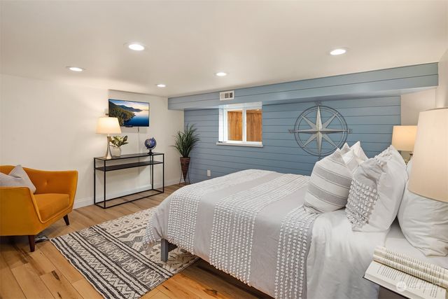 a bedroom with a bed and wooden floor
