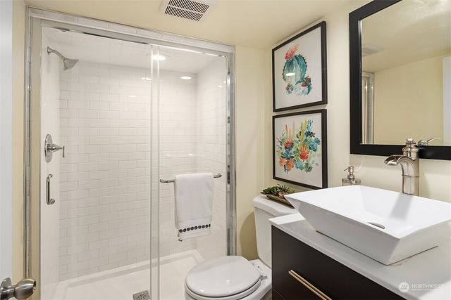 a bathroom with a sink a toilet a shower and a mirror