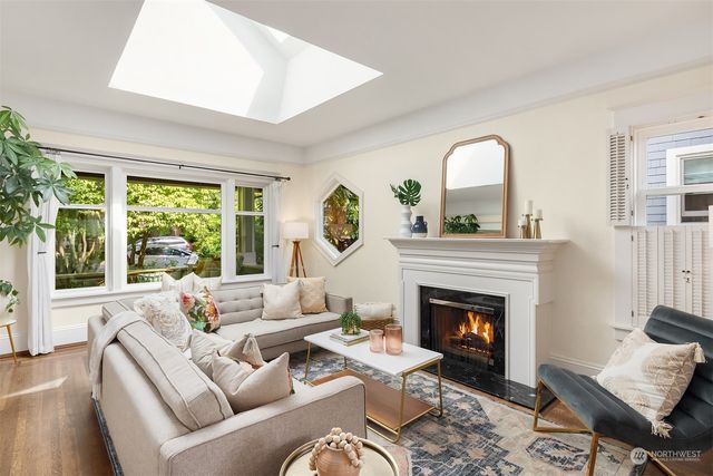 a living room with furniture a fireplace and a large window
