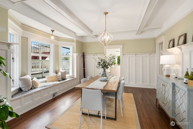 a dining room with furniture a chandelier and wooden floor