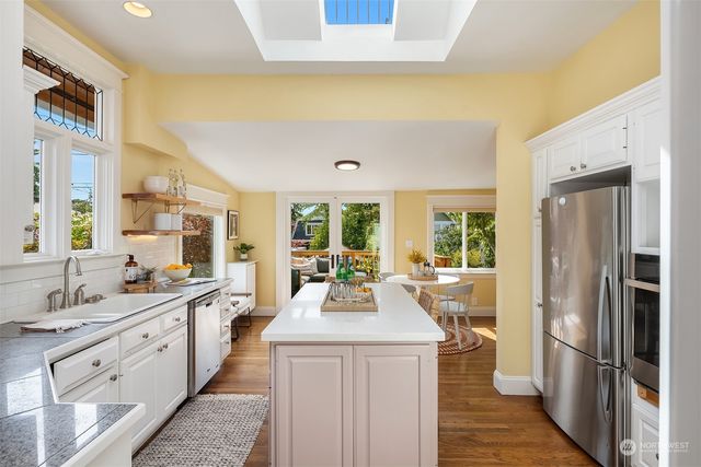 a view of a kitchen with a sink dishwasher a refrigerator with wooden floor