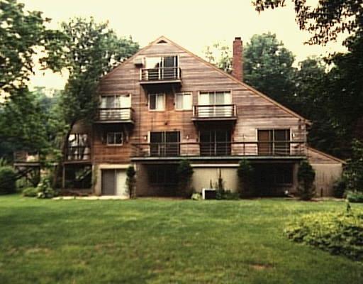 a front view of a house with a yard and trees