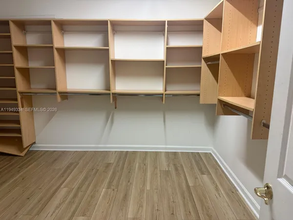 a view of walk in closet with empty racks