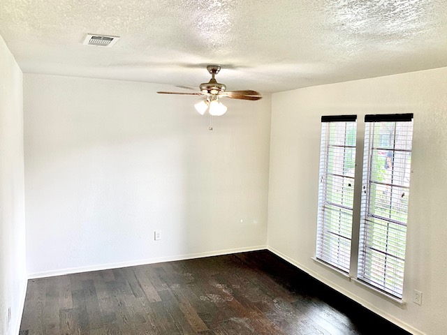 6114 Hogan Avenue Austin, TX 78741 - Photo 5 of 16 an empty room with windows and ceiling fan