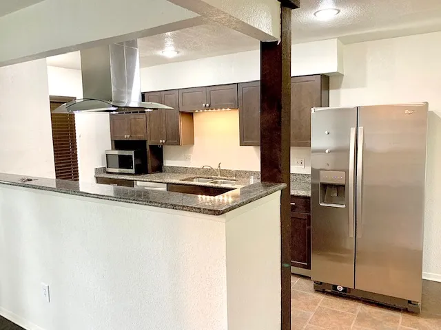 a kitchen with stainless steel appliances a refrigerator sink and stove