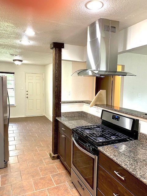 6114 Hogan Avenue Austin, TX 78741 - Photo 8 of 16 a kitchen with a stove and a granite counter tops