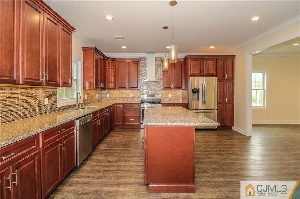 64 Winthrop Road Edison, NJ 08817 - Photo 13 of 24 a large kitchen with stainless steel appliances kitchen island granite countertop a refrigerator a stove and a sink with wooden cabinets