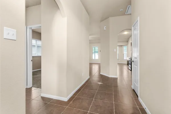 a view of a hallway with wooden floor and a bathroom