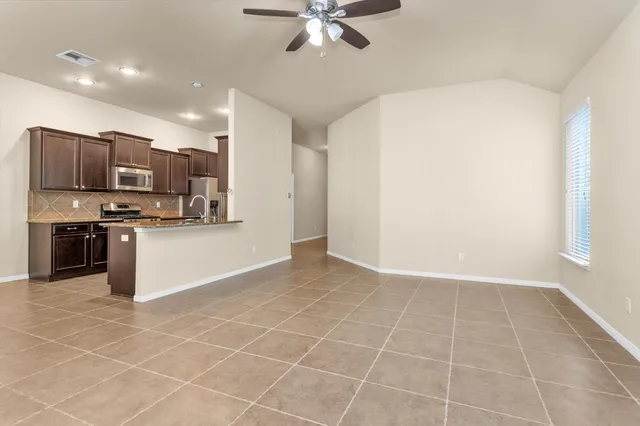 a view of kitchen with stainless steel appliances a refrigerator and a stove top oven