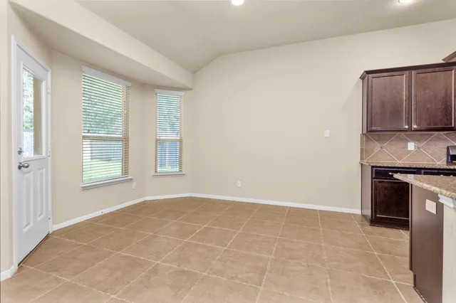 a view of an empty room with a fireplace and a window