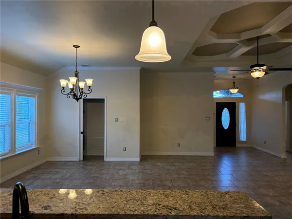 a view of a livingroom with a chandelier wooden floor and a chandelier