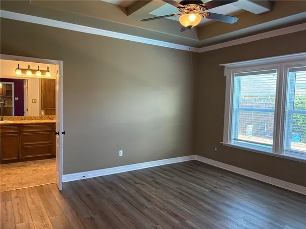 a view of an empty room with window and wooden floor