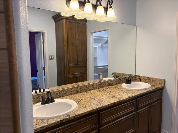 a bathroom with a granite countertop sink and a mirror