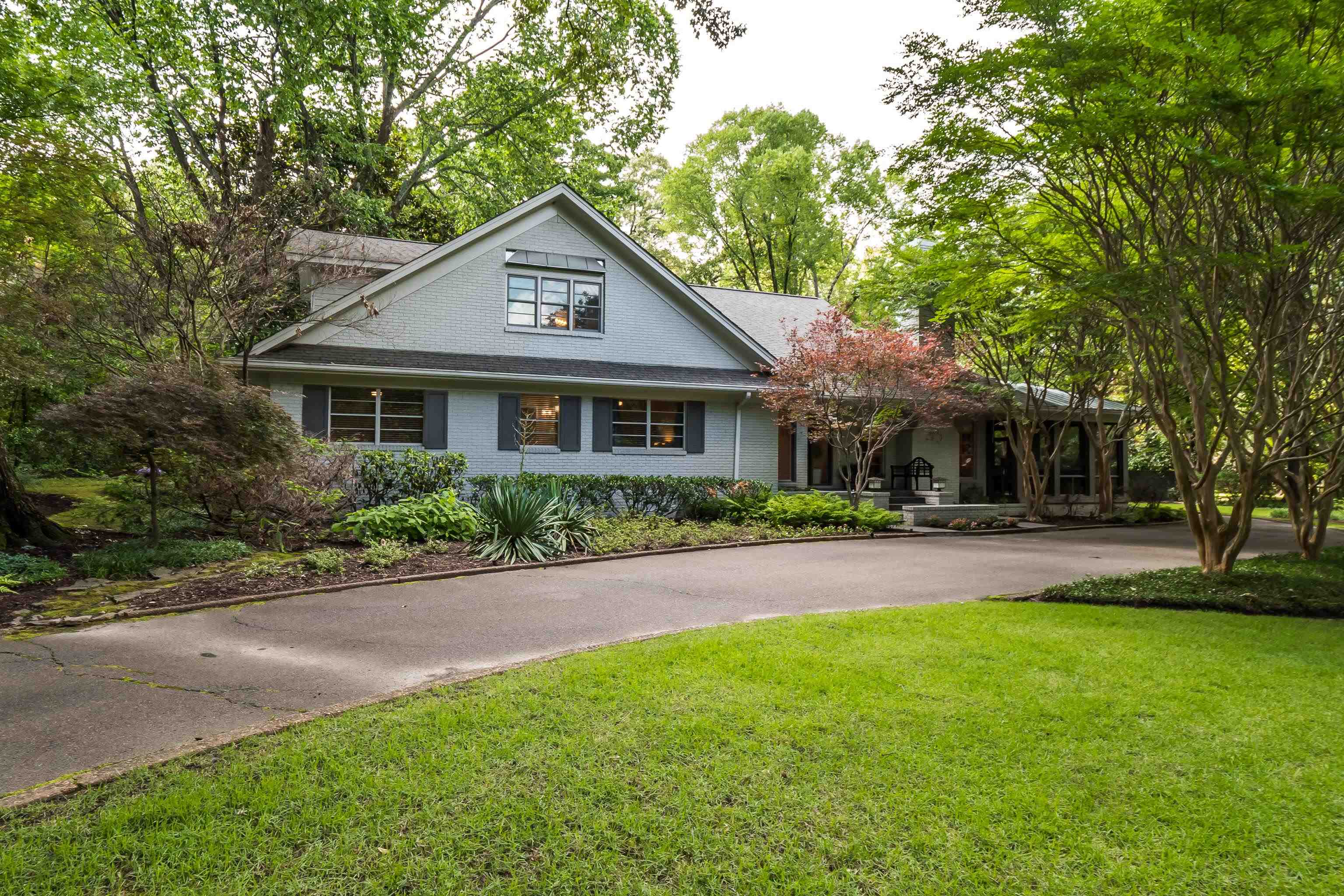 a front view of a house with a yard and trees