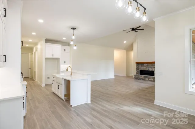 a large kitchen with granite countertop a large counter top a sink stainless steel appliances and cabinets