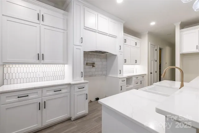 a kitchen with a white cabinets and chandelier
