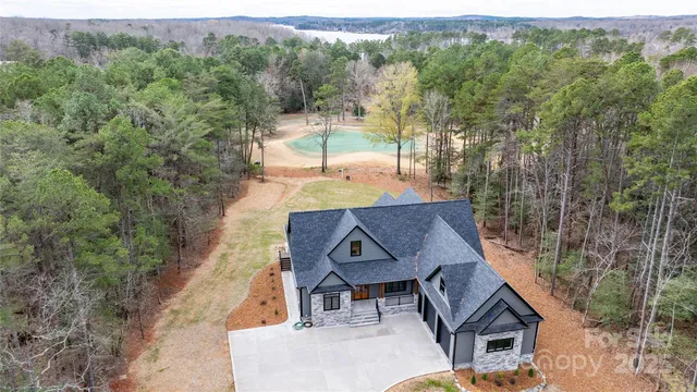 an aerial view of a house with large trees