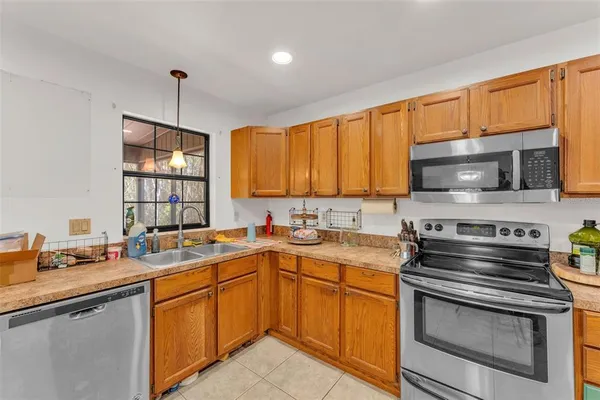 a kitchen with stainless steel appliances a stove sink microwave and cabinets
