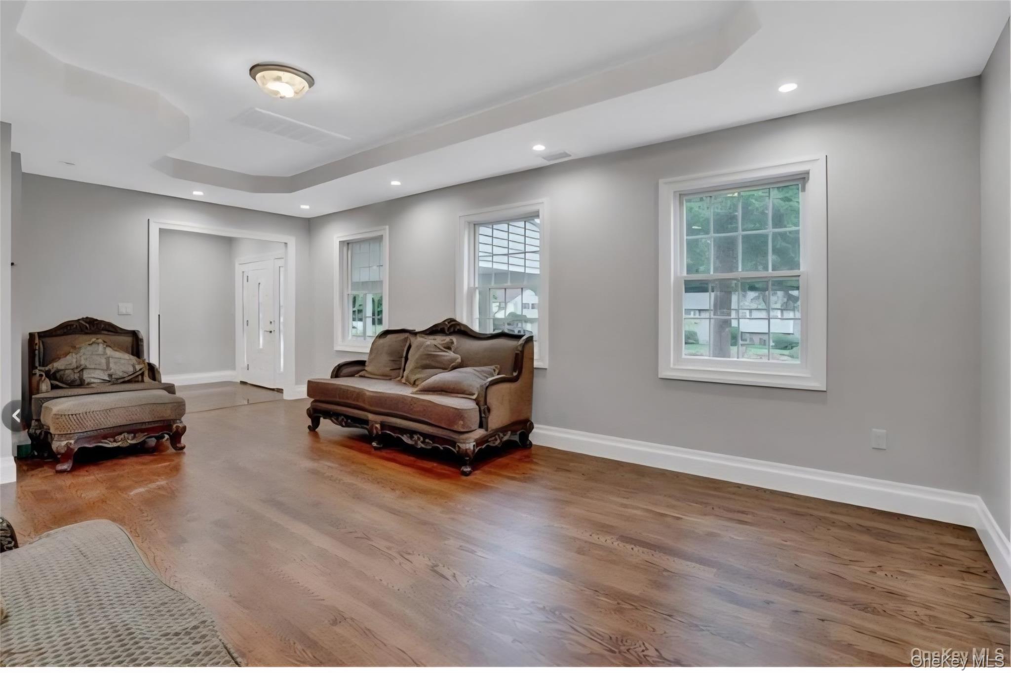 9 Linda Lane, Unit 101 Pearl River, NY 10965 - Photo 6 of 20 Living area featuring recessed lighting, wood finished floors, and a tray ceiling