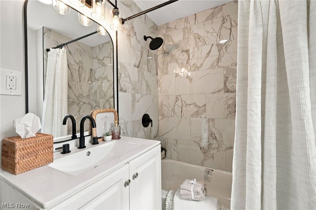 1173 Yellowstone Road Cleveland Heights, OH 44121 - Photo 30 of 44 White vanity with integrated sink, matte black faucet, and arched mirror