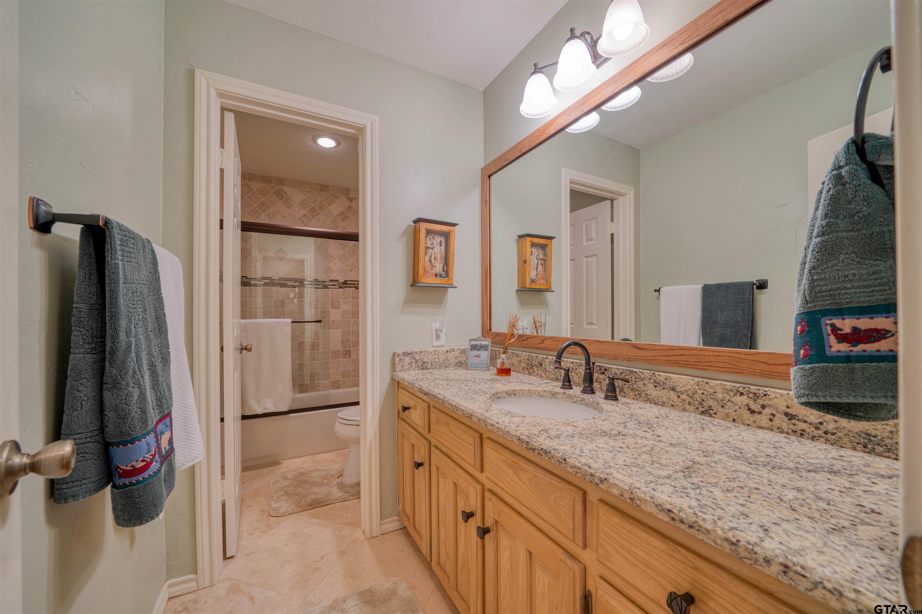144 King Lyle Road Scroggins, TX 75480 - Photo 41 of 48 a bathroom with a granite countertop sink and a mirror