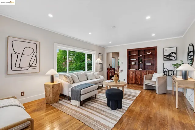 a living room with furniture large window and wooden floor