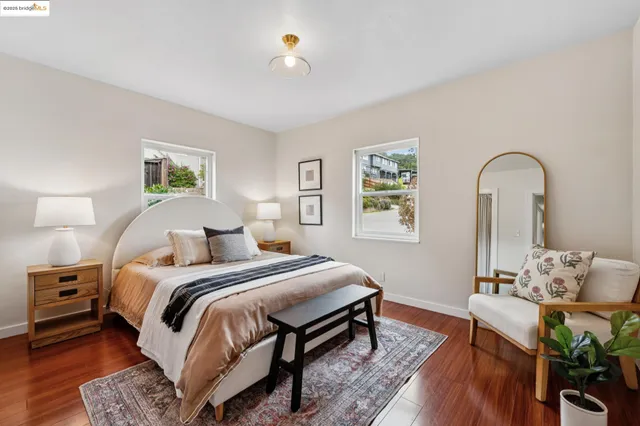 a bedroom with a bed wooden floor and window