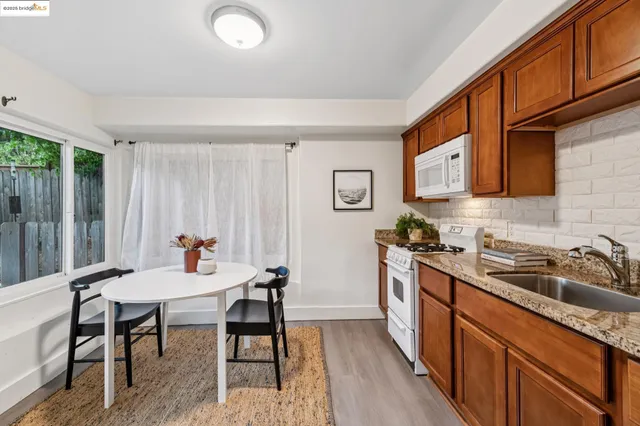 a kitchen with stainless steel appliances a white stove top oven sitting next to a window