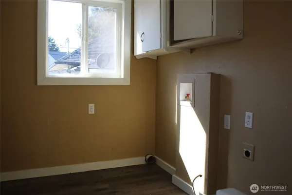 a view of a small space with wooden floor and a window