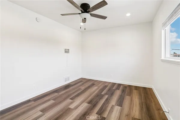 an empty room with a window and a ceiling fan