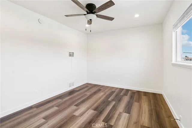 an empty room with a window and a ceiling fan