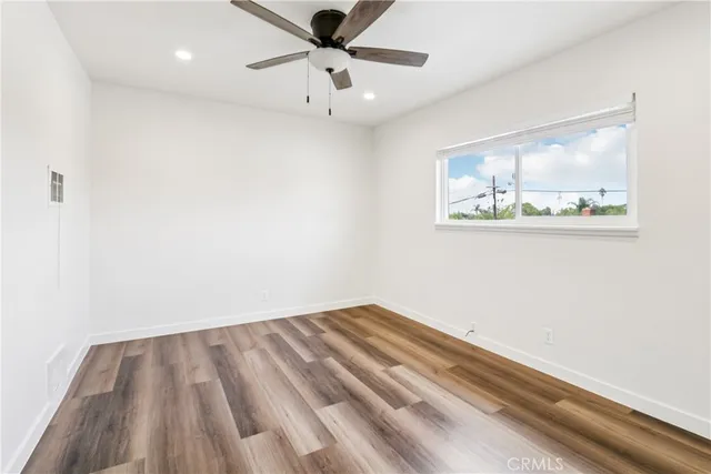 an empty room with a window and a ceiling fan