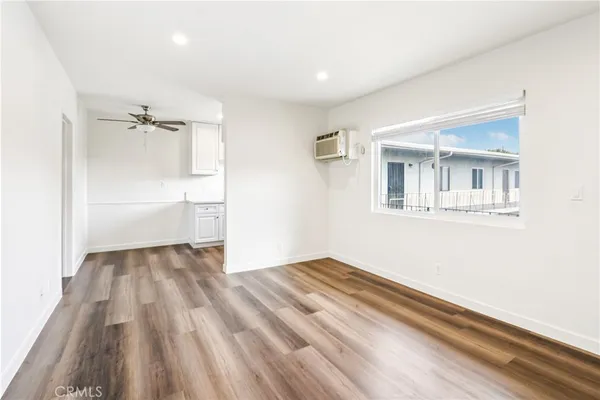 a view of a room with wooden floor and white walls