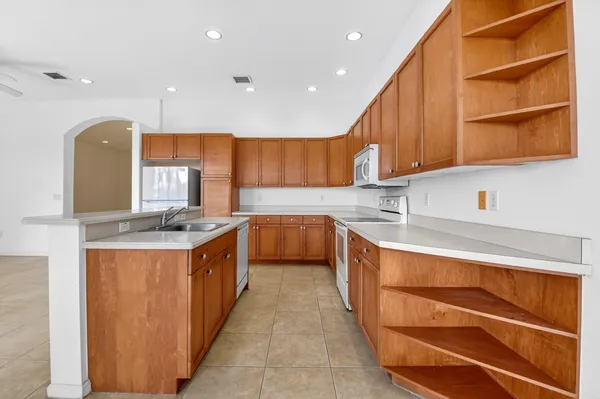 a kitchen with stainless steel appliances granite countertop a sink a stove and a refrigerator