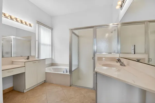 a bathroom with a tub sink and mirror