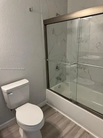 a white toilet sitting next to a bath tub and shower