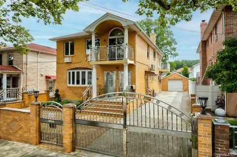 a view of a white house with large windows and a table and chairs