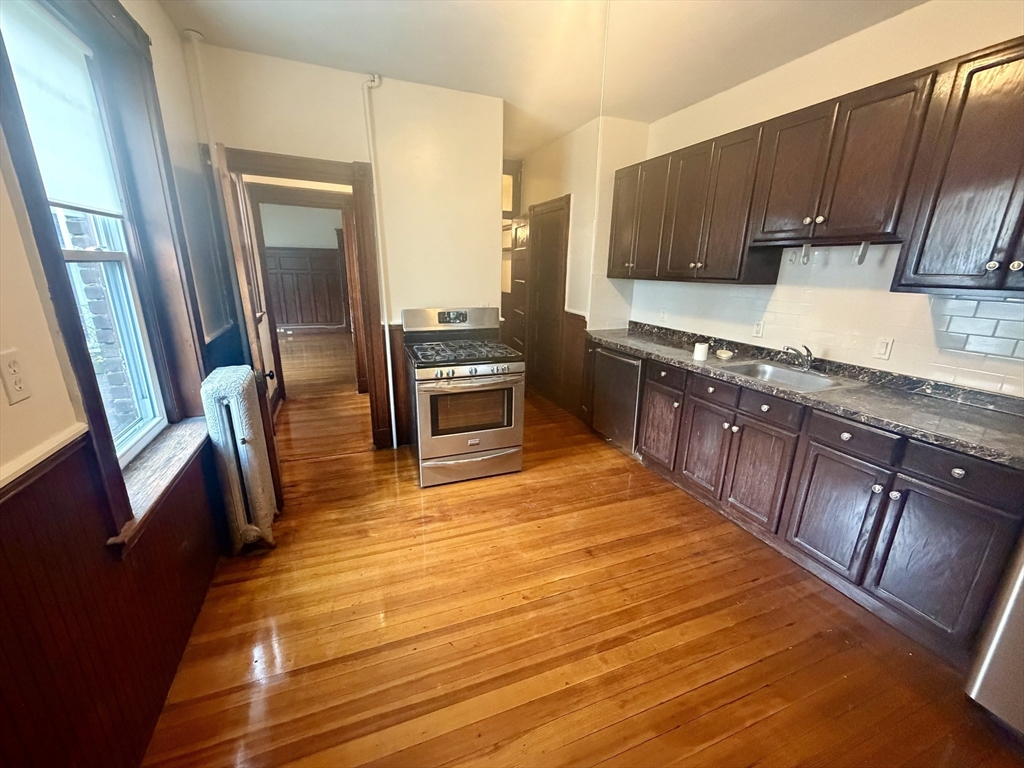 a kitchen with stainless steel appliances granite countertop a stove a sink and a refrigerator