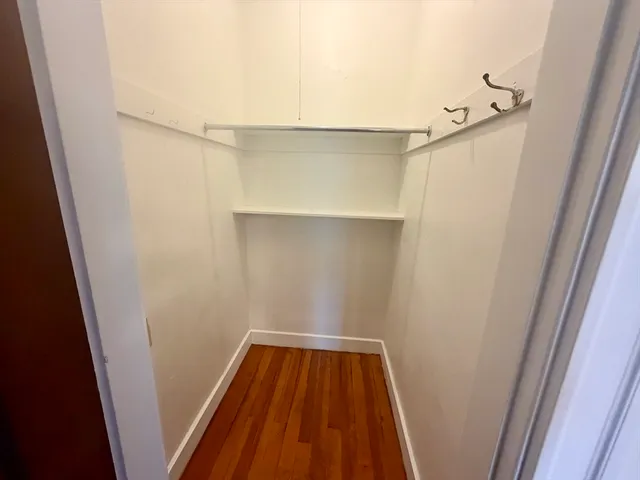 a view of walk in closet with wooden floor