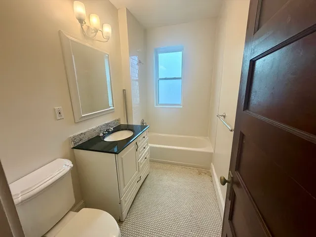 a bathroom with a granite countertop sink toilet and shower