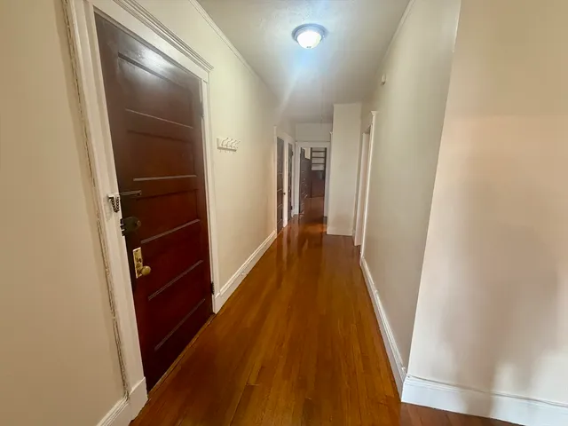 a view of hallway with wooden floor