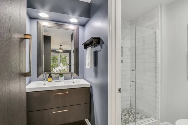 a bathroom with a sink a mirror and shower
