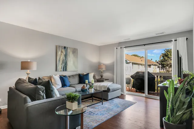 a living room with furniture a large window and a wooden floor