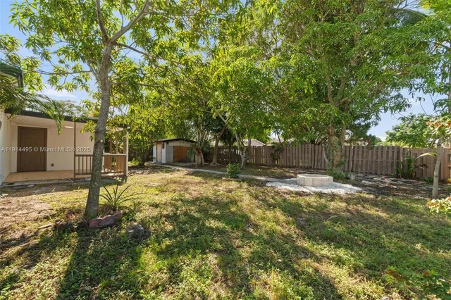 a view of a yard with plants and trees