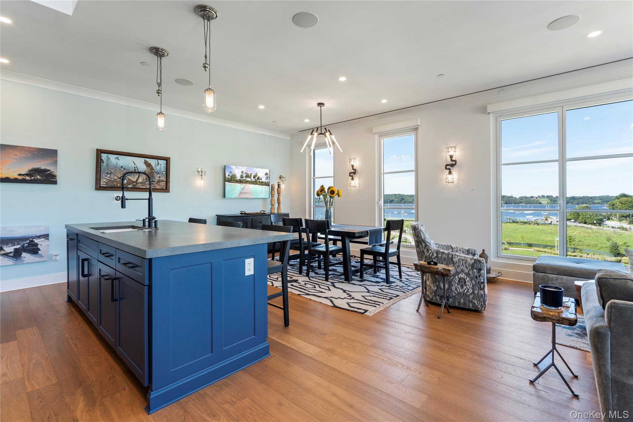 100 Garvies Point Road, Unit 1309 Glen Cove, NY 11542 - Photo 5 of 36 Kitchen featuring blue cabinetry, hanging light fixtures, and a kitchen island