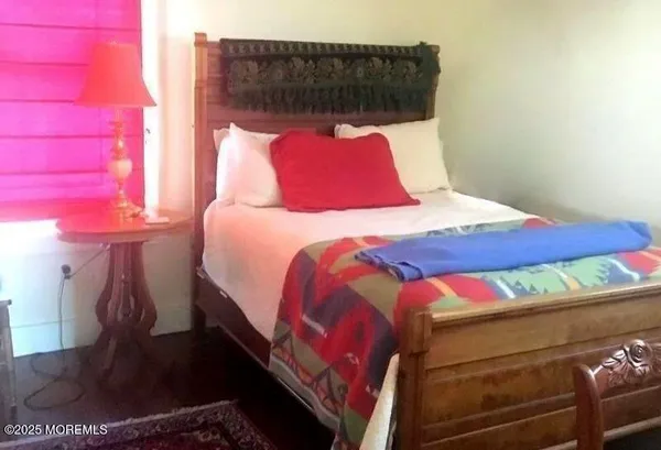 a bed sitting in a bedroom next to a window with rug