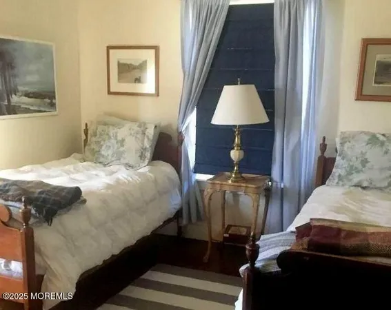 a bedroom with a bed and a lamp on dresser