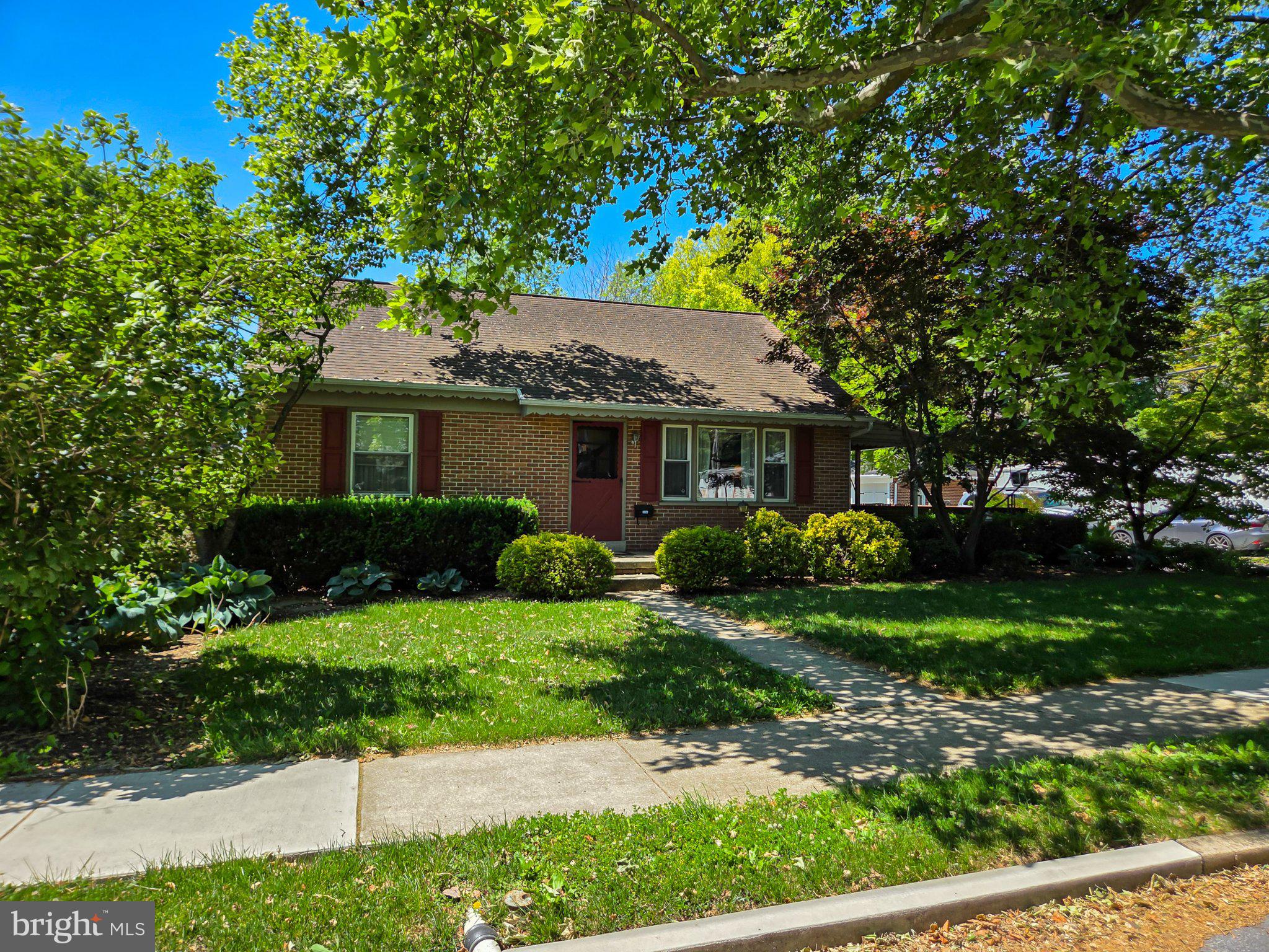 524 Locust Street Denver, PA 17517 - Photo 2 of 36 Charming brick home with lush greenery.