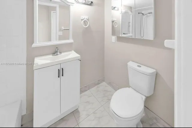 a white toilet sitting next to a bathroom sink